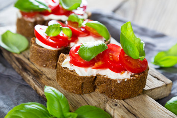 Bruschetta with cream cheese cherry tomatoes and basil