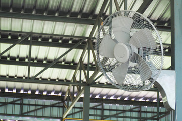 metal fan hanging on pole