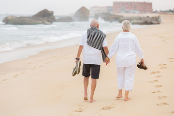 senior couple walking on the beach - 116788382