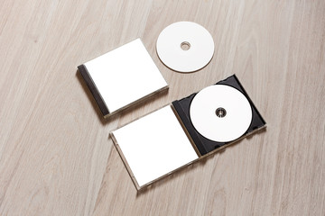 Closed compact disc template with plastic box case with white isolated blank for branding design and open box with booklet. CD jewel mock up with clean free space on wooden table. Perspective view