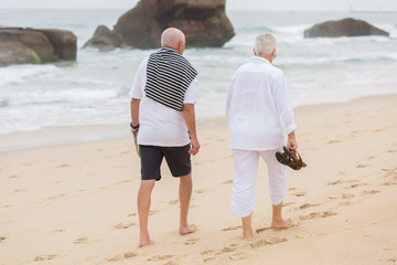 senior couple walking on the beach