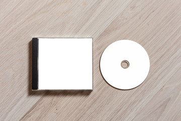 Compact disc template with plastic box with white isolated blank for branding design. CD jewel case mock up with clean free space with booklet for print on wooden table. Top view - obrazy, fototapety, plakaty
