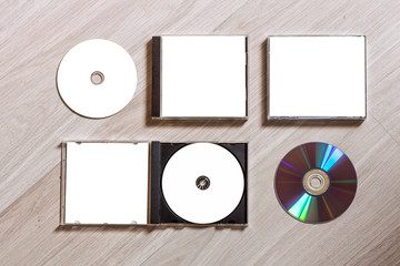 Full set compact disc template with plastic box case with white isolated blank for branding design and open box with booklet and back side. CD jewel case mock up with free space on wooden table. - obrazy, fototapety, plakaty