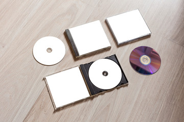 Full set compact disc template with plastic box case with white isolated blank for branding design and open box with booklet and back side. CD jewel case mock up with clean free space on wooden table.