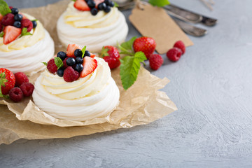 Pavlova cakes with cream and fresh berries