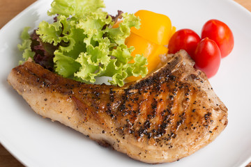 Grilled Pork serve with colorful salad on wooden table