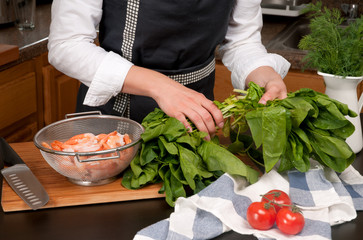 Woman cooking shrimps in the kitchen