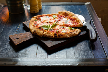 Pizza Margherita freshly baked on a table in cafe