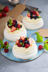 Pavlova cakes with cream and fresh berries