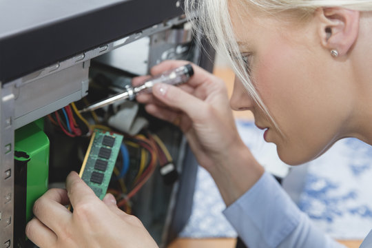 Woman assembling Random Access Memory at computer