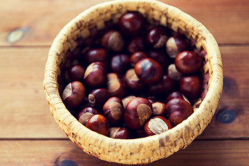 close up of chestnuts in basket on wooden table
