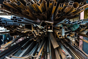 Perspective of pile of construction metals in factory. They consist of square and rectangular steel...