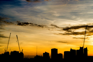 Silhouette construction during sunrise and orange sky.