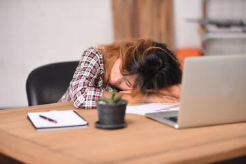 Young Businesswoman Sleeping In Front Of Computer At Desk