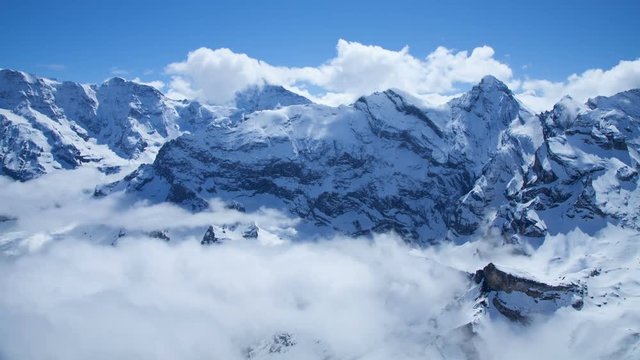 Time Lapse of a snow covered mountain peaks in the Swiss Alps with clouds blowing past.