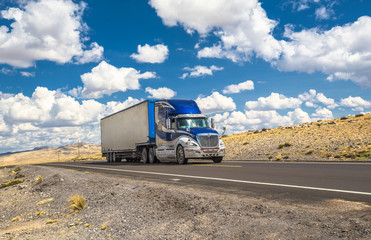 Fototapeta premium Niebieska ciężarówka porusza się na autostradzie