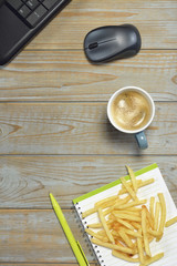 Wooden desk table with laptop computer, tablet,cup of coffee,sandwich,green  pen, mouse and notebook,with empty copy space

