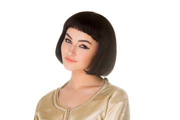 Smiling girl with Cleopatra's make-up and haircut posing in studio