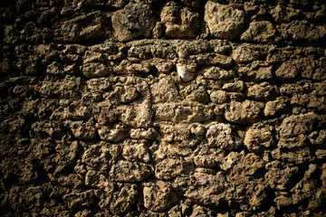 Old stone wall with cracks. Toned