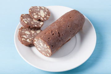 Homemade cake on a white plate on blue background. Selective foc