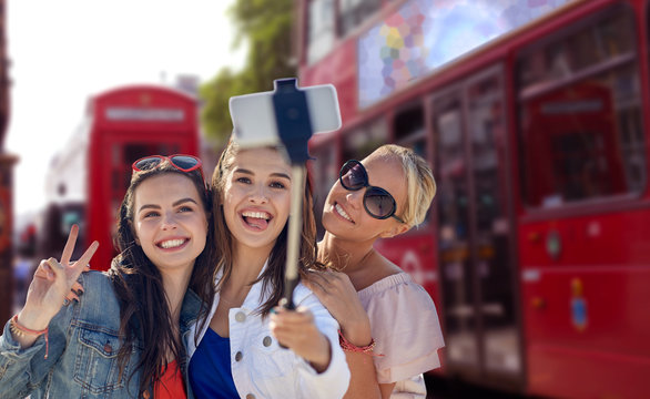 group of smiling women taking selfie in london