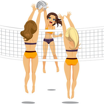 Active woman jumping doing smash attack while two athletic volleyball players are blocking ball