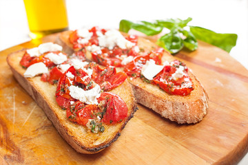 Bruschetta with tomato, soft cheese, basil, garlic and olive oil, horizontal