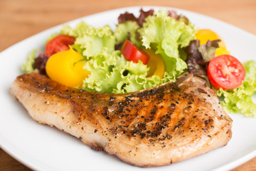 Grilled Pork serve with colorful salad on wooden table