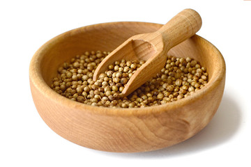 Coriander seed in wooden bowl isolated on white background