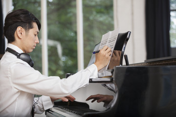 Young man annotating sheet music