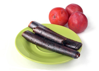 from plums pastilles lie on the green plate and fresh plums