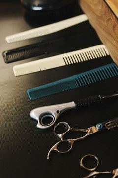 A row of hair combs and sharp hair cutting scissors.