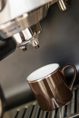 espresso machine making coffee and pouring in a brown  cup