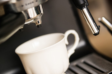espresso machine making coffee and pouring in a white  cup