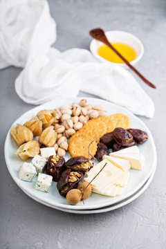 Cheese plate with crackers, dates and nuts