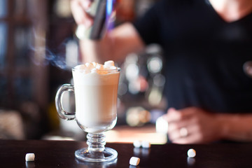 Cocoa with marshmallow. Bartender is making cocktail at bar coun