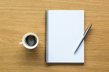 Scrivania d'ufficio con blocco note, penna e tazza di caffè