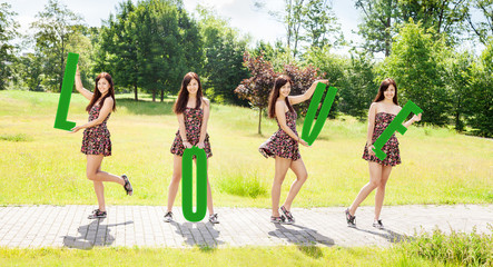 Fototapeta premium young smiling girls holding letters with the word love