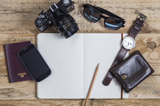 Essentials for travelling including passport smartphone camera sunglasses watch and wallet - Powered by Adobe