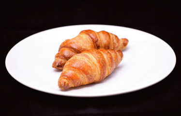 Two croissants on white plate 
