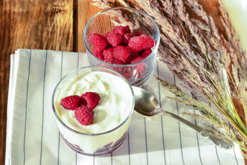 Juicy raspberry in a white yogurt on rustic kitchen. Berry puddi