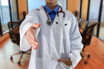 Female doctor giving hand for handshake in room