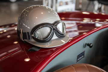 Helmet and glasses on a luxury convertible sports car.