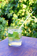 Nutritious detox water with lime and mint in a glass on the wood background