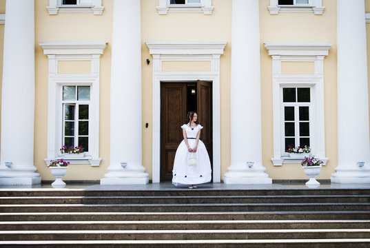 Girl in ancient dress with crinoline on the background of the building with columns