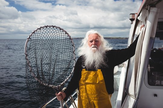 Portrait of fisherman holding fishing net