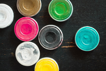 Aquagrim face paints on black wooden background