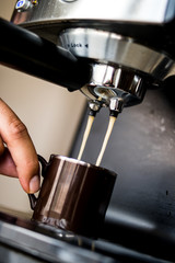 espresso machine making coffee and pouring in a brown  cup