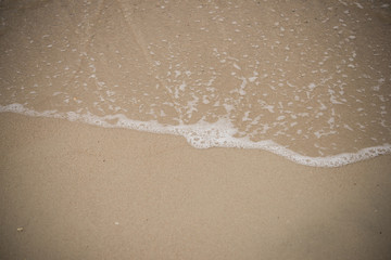 Plakat Soft wave of blue ocean on sandy beach. Background.
