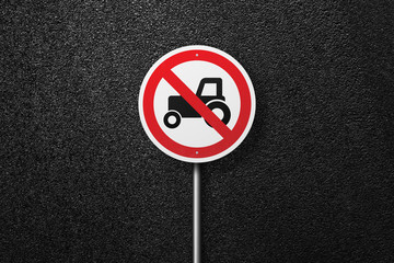 Road sign circular shape with a picture of the tractor on a background of asphalt. The texture of the tarmac, top view.